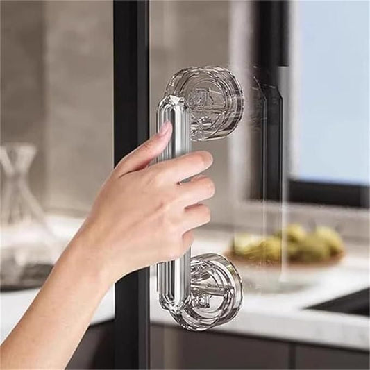 Clear glass door handle being held by a hand in a kitchen setting